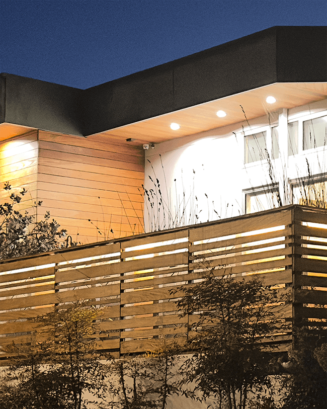 Modern wood fence lit from the inside out at night